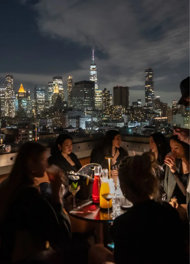 a group of people sitting on a roof top with a view of the city