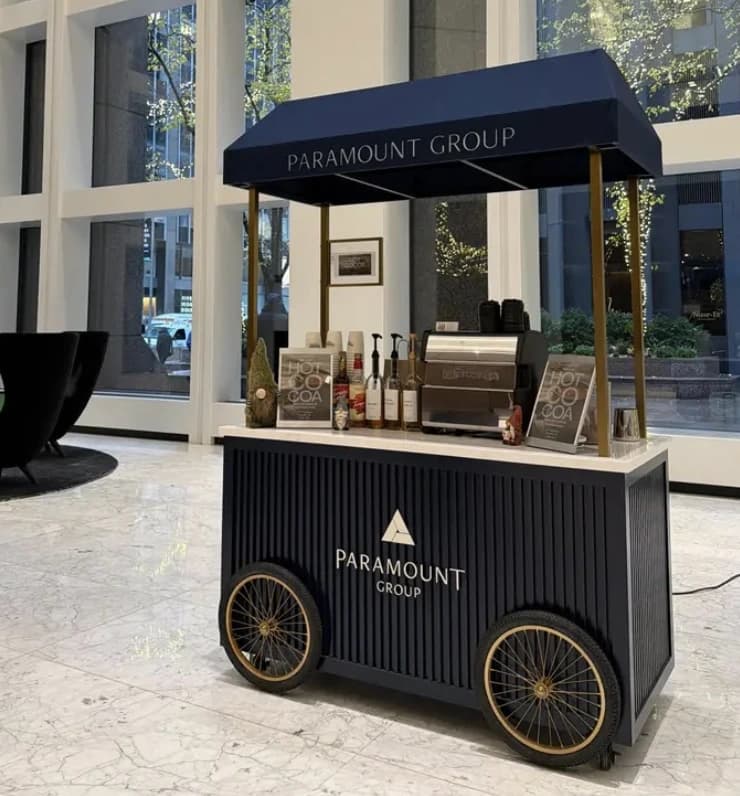 Paramount Group wheeled coffee cart in marble lobby with navy awning