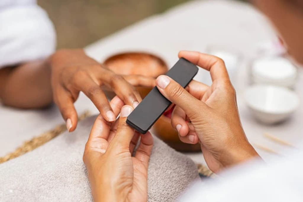 a close up of someone getting their nails done