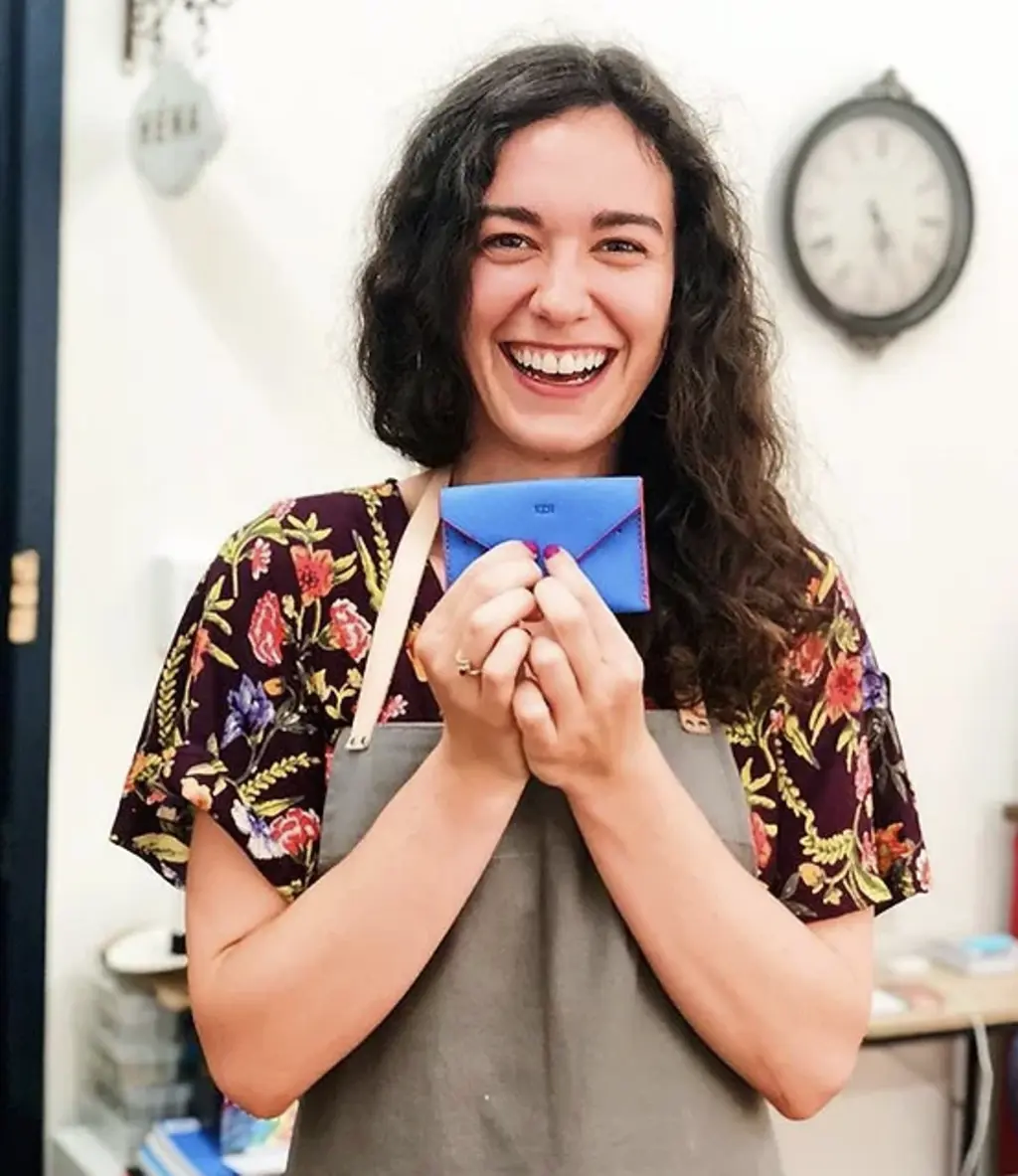 a women holding up a blue leather card holder