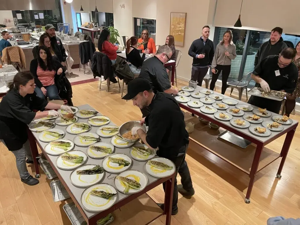 a chef cutting something on a tray in the kitchen