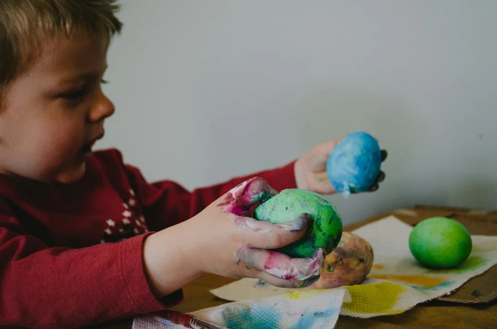 a child coloring and decorating an object