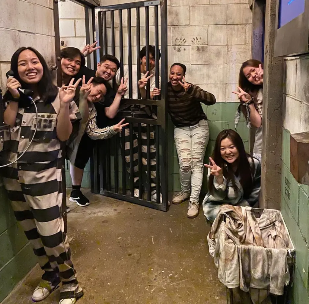 people opening a large metal door in an escape room