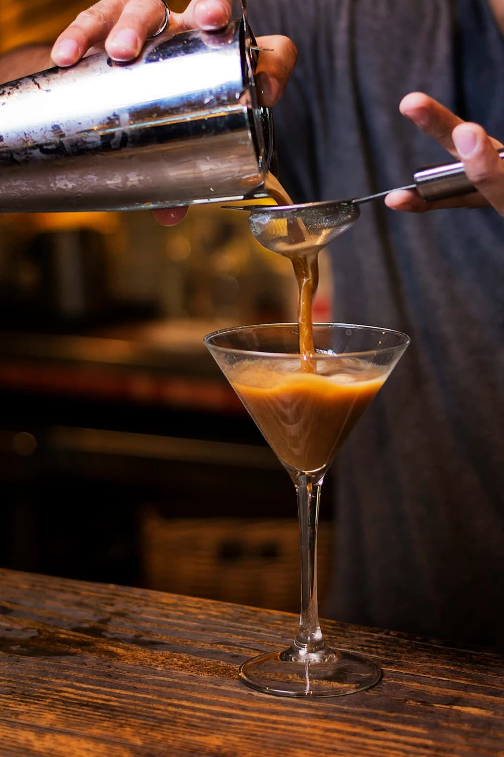 someone pouring a martini
