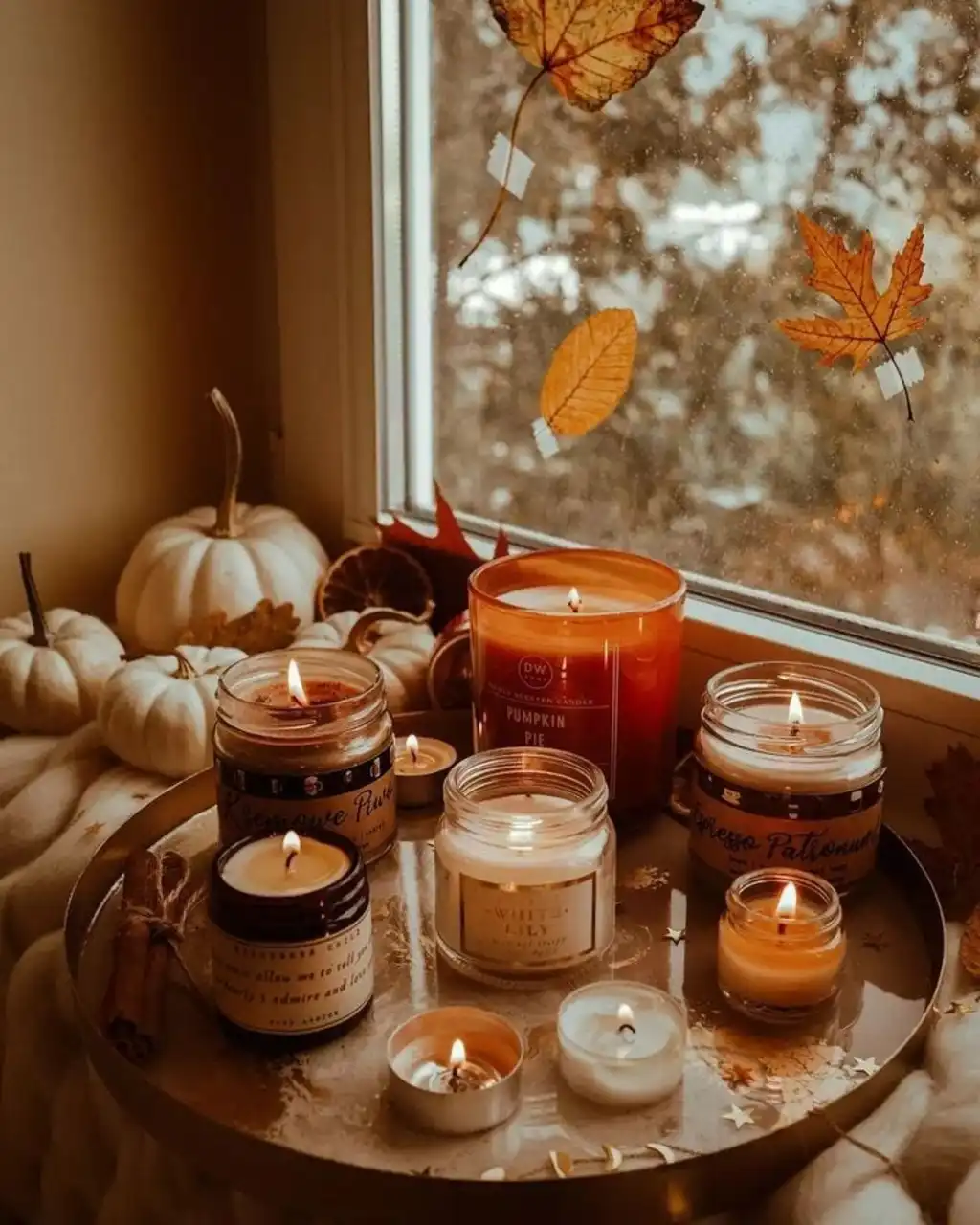 a group of fall candles on a tray all lit