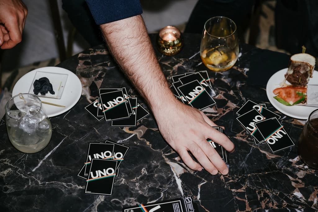 A table with UNO cards and snacks, showing a casual game night with light refreshments.