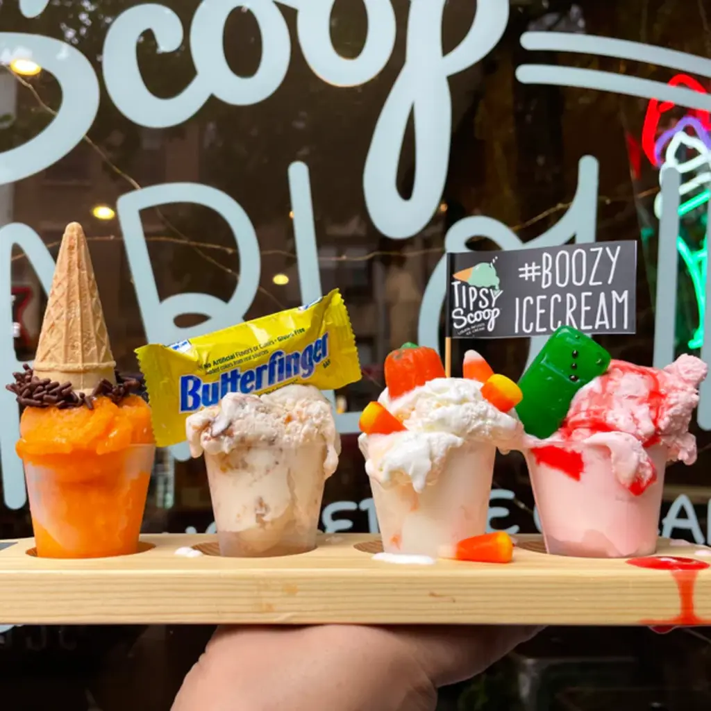A creamy cocktail with peanut butter rim and a Reese's cup garnish in a martini glass, topped with Reese’s Pieces candy.