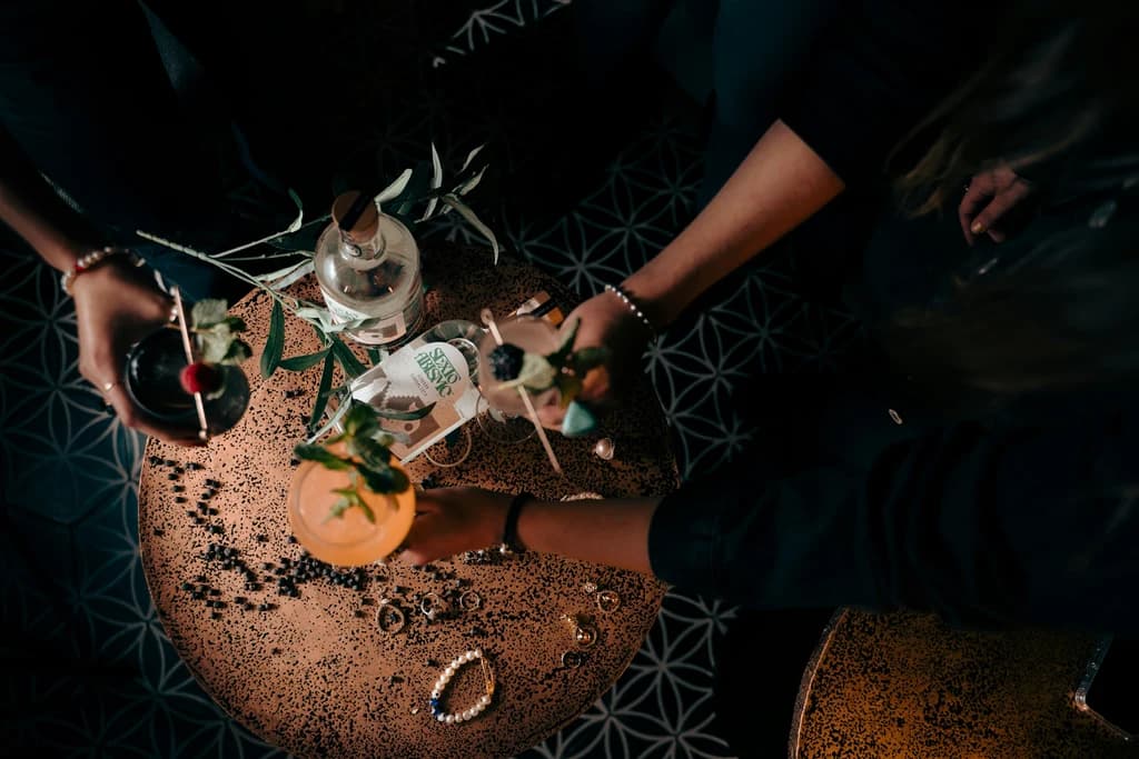 people cheersing drinks with different ingredients on the table