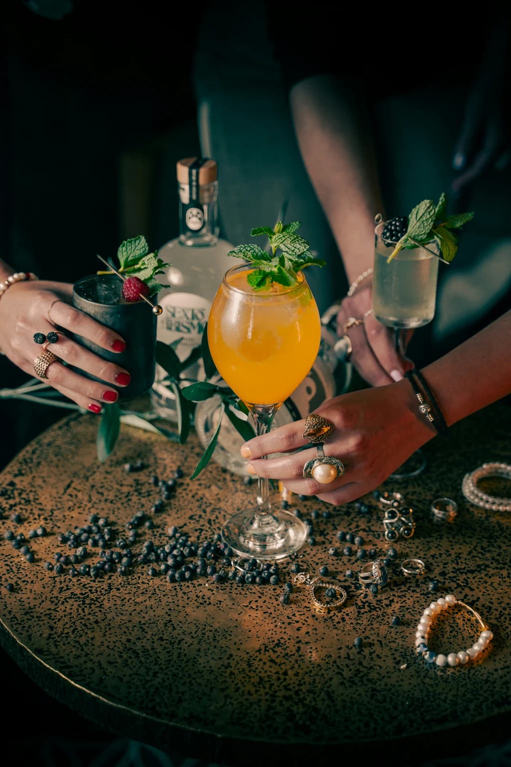 different mixed drinks on a table wiht ingredients around them