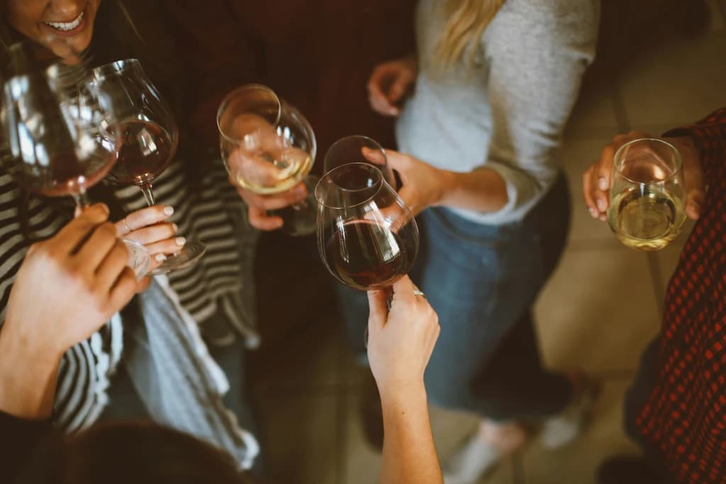 a close up from the center of a circle of people cheersing wine