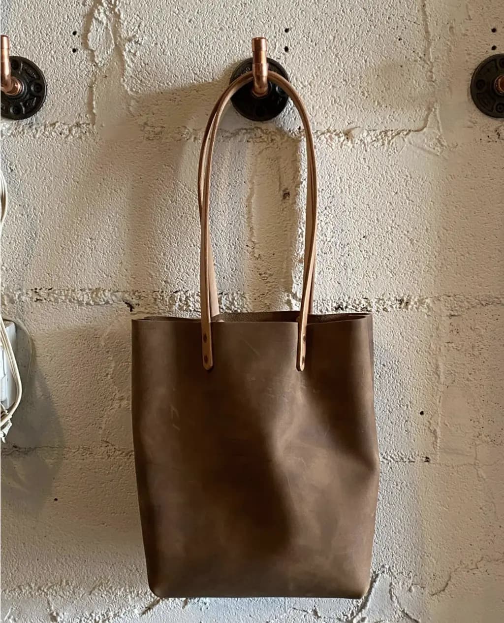 a leather bag hanging on a hook for display