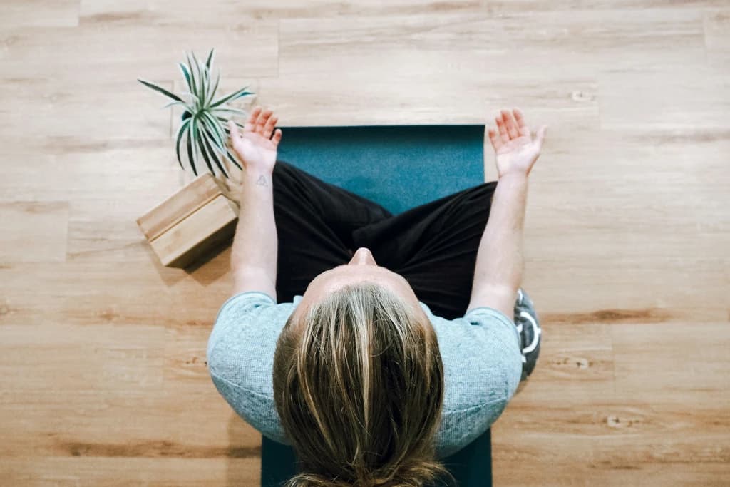 a top view of someone sitting on a mat and meditatibng
