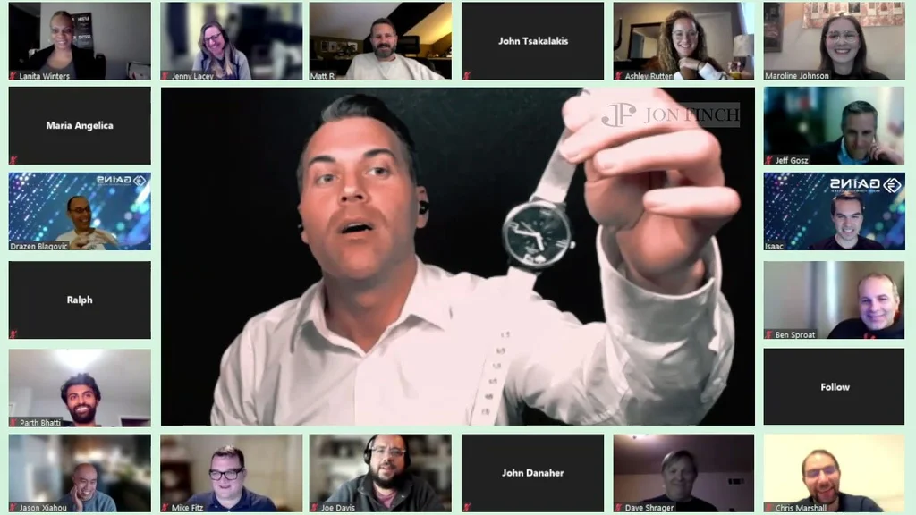 A man showcasing a watch during a virtual meeting, surrounded by participants' video call windows.