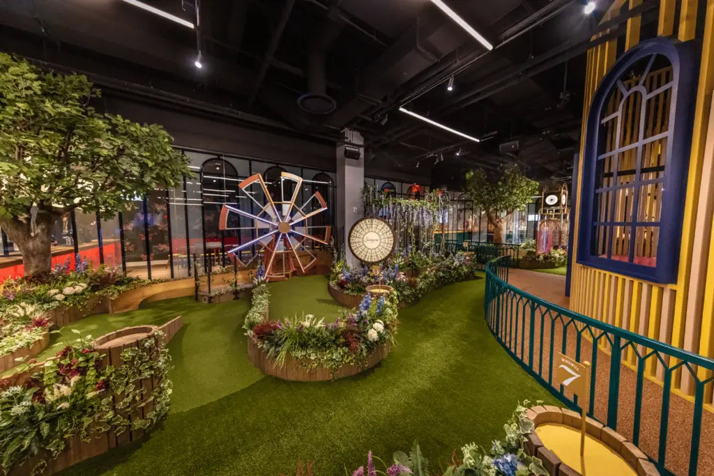 a view of the minigolf course with flowers and structures
