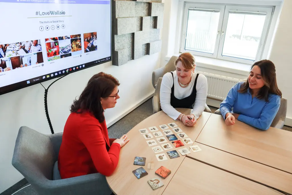 people sitting around a table looking at clues on cards