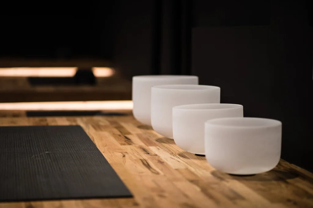 a yoga mat with sound bowls next to it