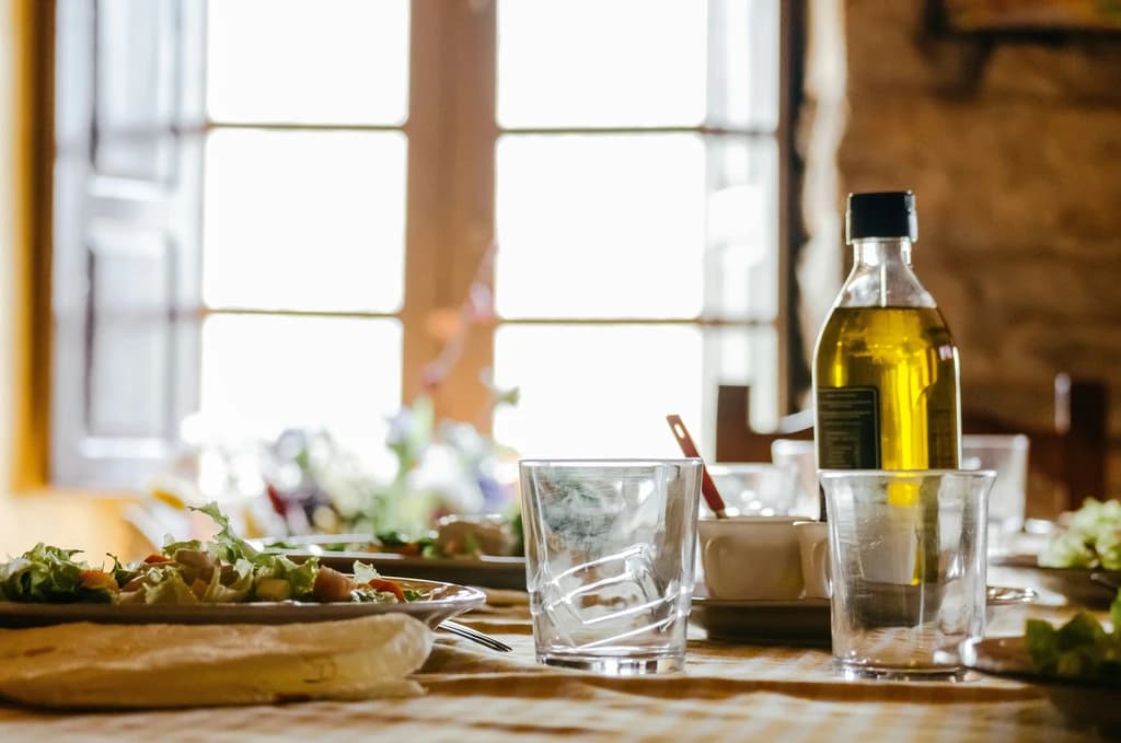 a table wiht olive oil, bread, and glasses