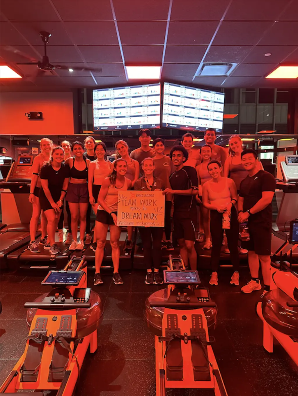 a group of people standing in a class and holding a sign that says team work