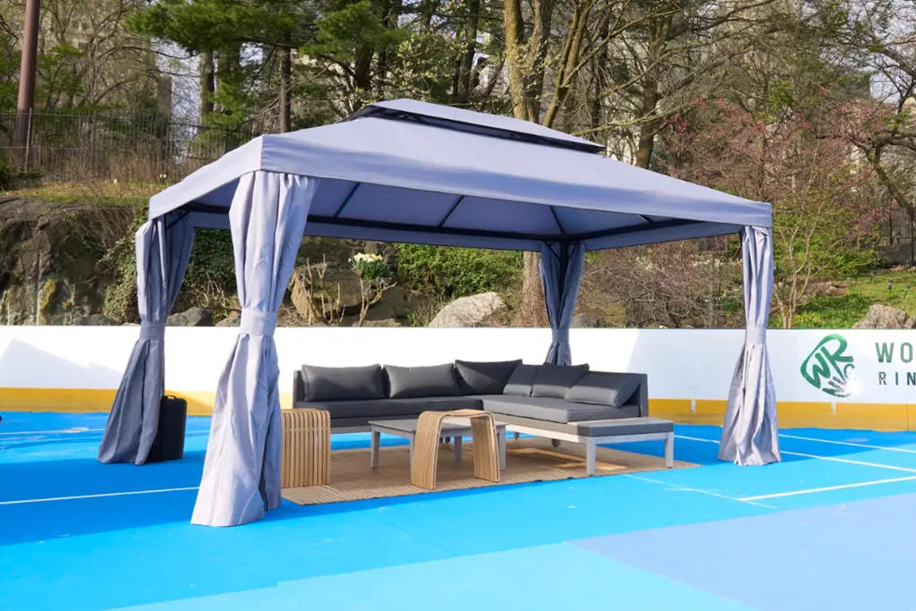 covered lounge area in the middle of a pickleball court