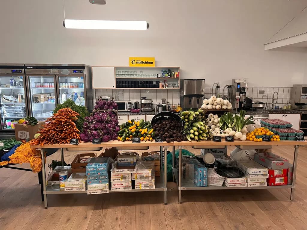 a box of produce with fruits, vegetables, and other items around it