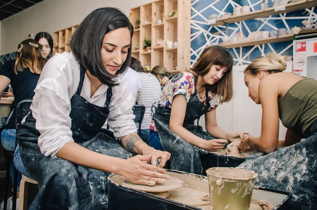a women using a pottery wheel in a class