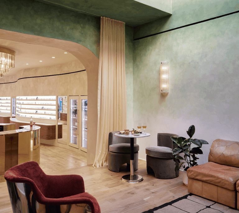 Stylish lounge with velvet chairs, marble table, and soft lighting in a modern, upscale setting.