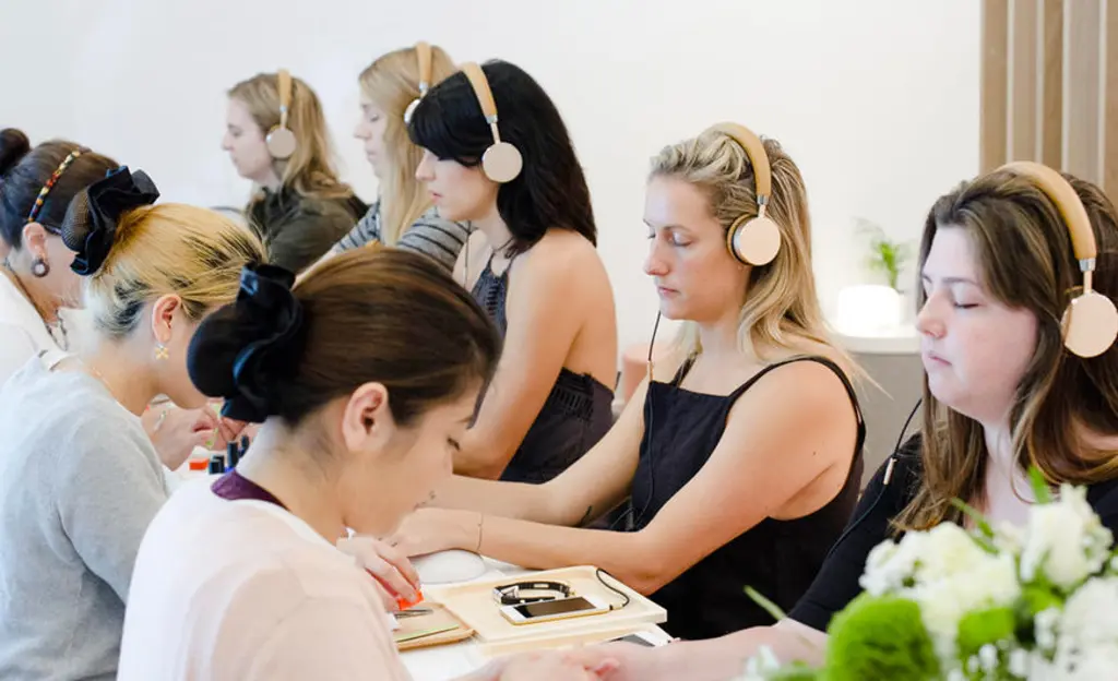 a group of people getting their nails done while listening to headphones