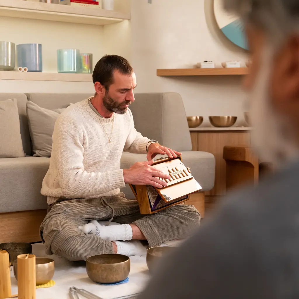 a man sitting on the ground playing sound healing music