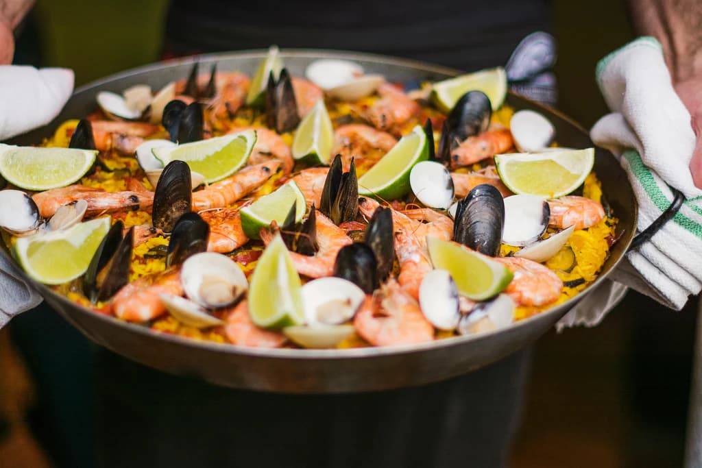 a close up of muscles and shrimp in a dish with garnish